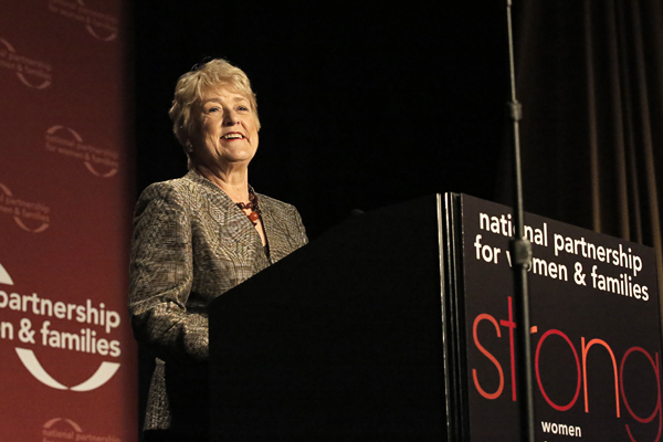Ellen Malcolm speaking at the podium on stage at the 2014 National Partnership luncheon