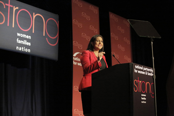 Karen Finney speaking at the podium on stage at the 2014 National Partnership luncheon