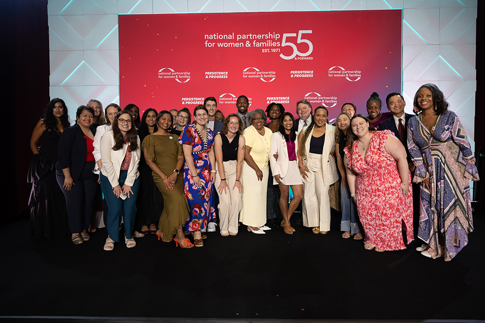 A large group of smiling NPWF staff members on stage after the 2026 Annual Event